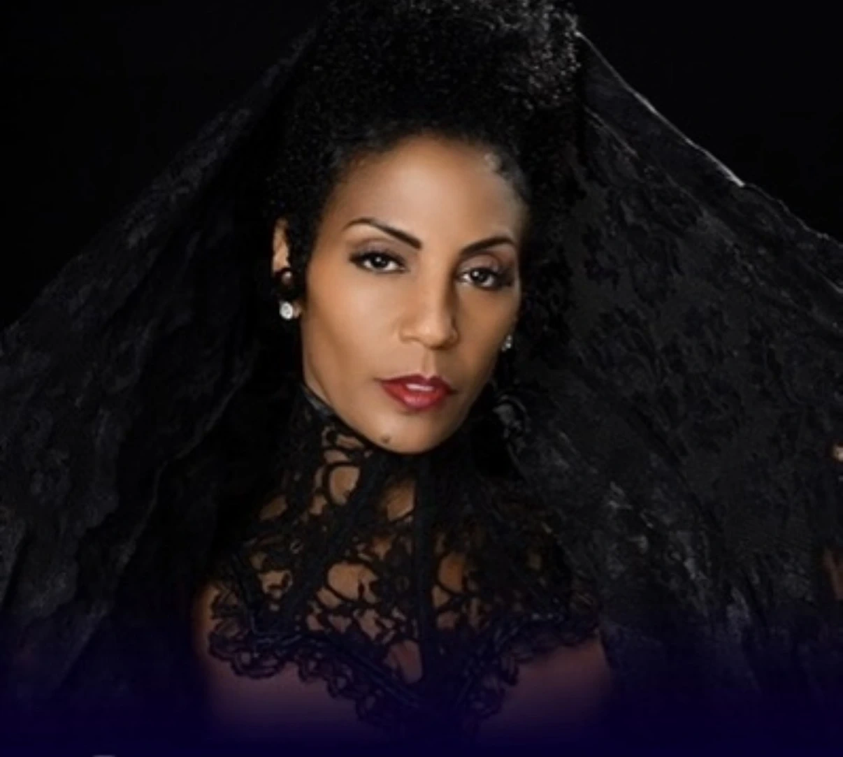 Portrait of Yvette Spears in black lace against a dramatic black background